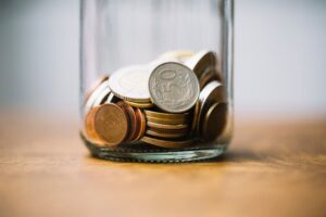 Zdjęcie przedstawiające słoik z monetami, obrazujący wpis o nowych opłatach za internat
