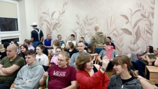 dzien_kobiet_internat7 Zdjęcie zrobione w świetlicy internatu przedstawia uczniów siedzących w rzędach krzeseł.