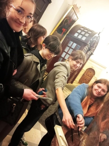 maturzysci_jasna_gora2 Grupa młodzieży stojąca w kościele przy kropielnicy i poświęcająca długopisy i ołówki.