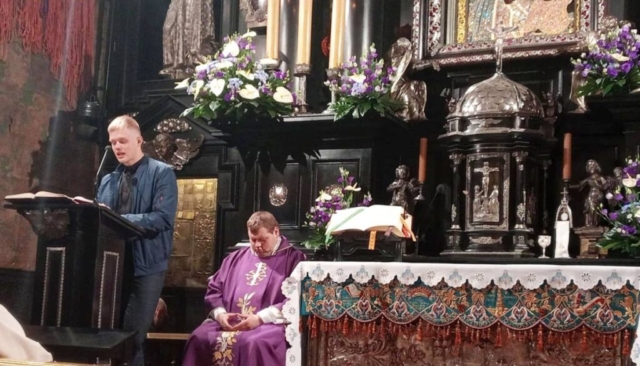 maturzysci_jasna_gora3 Wnętrze kościoła w Częstochowie z cudownym Obrazem Matki Boskiej Częstochowskiej, przy mównicy uczeń czytający tekst Pisma świętego, w tle siedzi ksiądz we fioletowym ornacie. Dekoracje z fioletowych i białych kwiatów wokół Ołtarza.