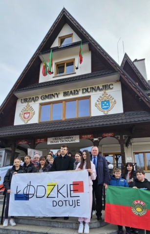 rajd_podhalanski01 Zdjęcie przedstawia grupę młodzieży, na tle budynku Urzędu Gminy Biały Dunajec. Część uczniów trzyma banery z napisem Łódzkie dotuje oraz logo LZS.