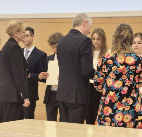 Zdjęcie przedstawia uczniów odbierających z rąk kuratora łódzkiego dyplomy na uroczystości wręczenia.