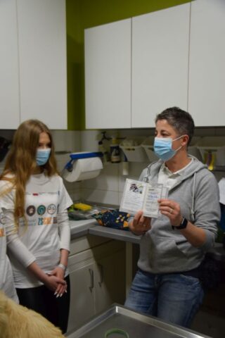 Uczestniczka praktyki zawodowej wraz z instruktorką w gabinecie weterynaryjnym. Instruktorka prezentuje dokument i objaśnia coś.