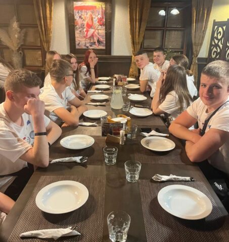 Uczestnicy praktyki zagranicznej we wnętrzu restauracji przy stole, czekają na posiłek.