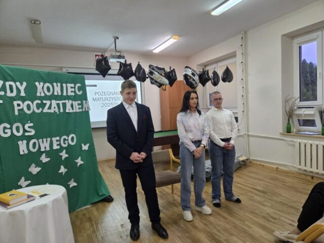 Uroczystość pożegnania maturzystów 2025 w internacie. Po prawej stronie dwóch uczniów, pośrodku ich kierownik internatu. Po lewej stronie tablica przysłonięta zielonym materiałem z napisem koloru białego "Każdy koniec jest początkiem czegoś nowego" i dekoracjami w kształcie motyli. U góry, przy suficie, podwieszone balony czarne i czarno białe z napisem Congrats. You did it! Graduate. W tle ekran z prezentacją i tekstem Pożegnanie maturzystów 2025.