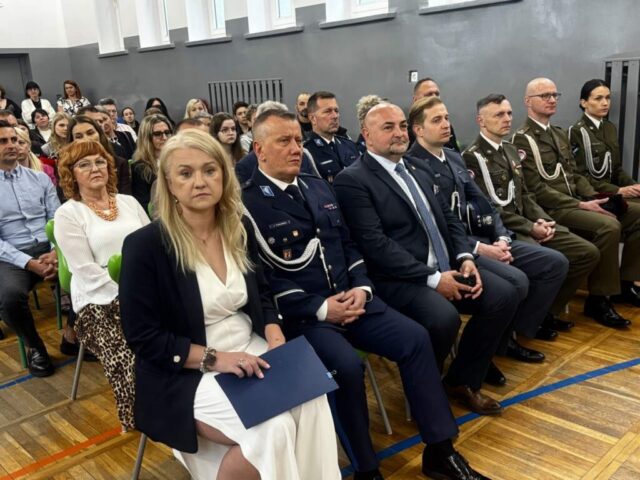 Dyrekcja Szkoły, zaproszeni goście, przedstawiciele Starostwa i służb mundurowych, rodzice i nauczyciele w sali gimnastycznej podczas uroczystego zakończenia roku klas maturalnych.