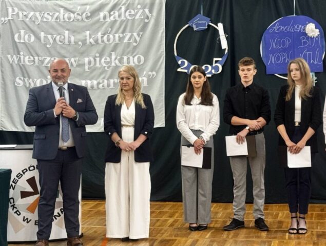 Pani dyrektor Szkoły, pan Wicestarosta i 3 uczniów podczas uroczystości zakończenia roku szkolnego dla klas maturalnych. Pan Wicestarosta przemawia.