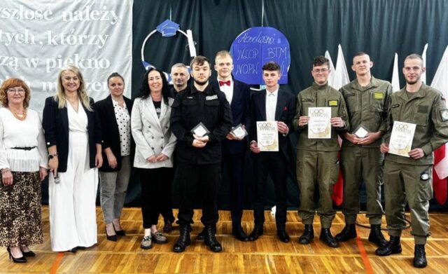 Uczniowie klas maturalnych OPW, LOp oraz Technikum, Dyrekcja i nauczyciele WF. Uczniowie trzymają w rękach dyplomy i statuetki za osiągnięcia sportowe.