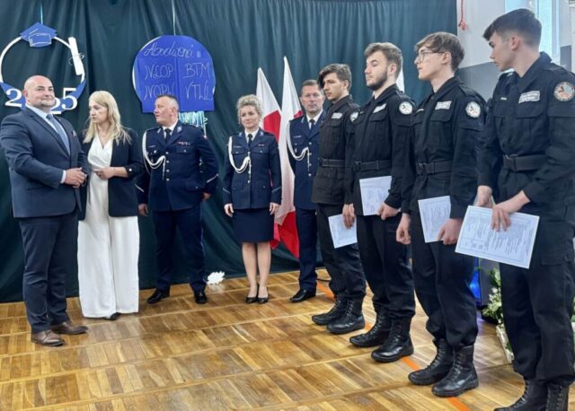 p. Dyrektor, p. Wicestarowsta, przedstawiciele służb mundurowych, policji oraz absolwenci klasy policyjnej w sali gimnastycznej na uroczystości zakończenia roku szkolnego klas maturalnych.