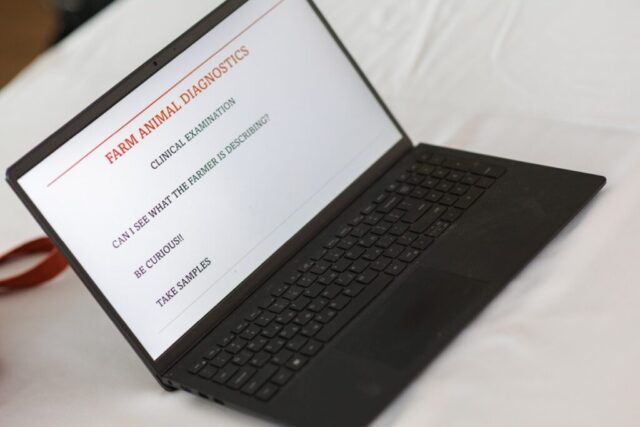 Laptop na stoliku. Na ekranie teks w języku angielskim: diagnostyka zwierząt gospodarskich, badanie kliniczne. Czy widzę, co opisuje hodowca? Bądź ciekawy! Pobierz próbki.