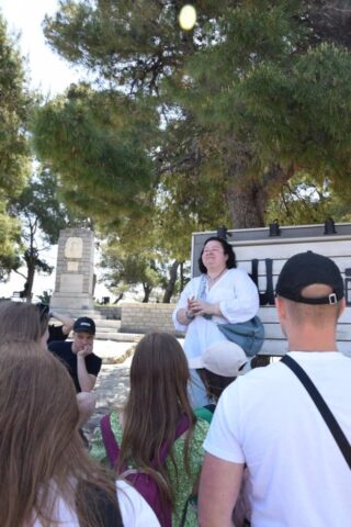 grecja_siodmy_dzien26 Grupa młodzieży i pani przewodnik przed monumentem.