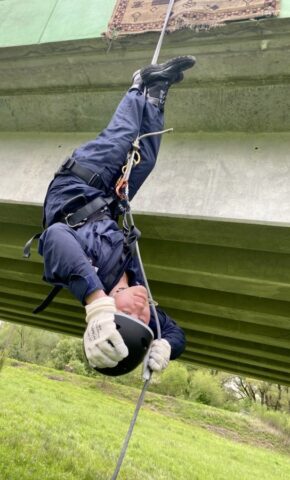 Uczestnik obozu szkoleniowego podczas ćwiczeń opuszczania na linie z mostu.