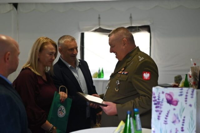 Pani Dyrektor ZS CKZ Bujny z koordynatorem i opiekunem klas opw wręczają żołnierzowi torbę upominkową z logo ZS CKZ w Bujnach.