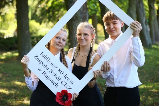 Młodzież szkolna trzymająca ramkę z napisem Jubileusz 80-lecia Zespołu Szkół CKZ w Bujnach.
