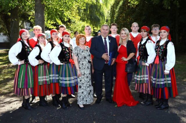 Grupa młodzieży w strojach ludowych, p. Dyrektor oraz p. wicedyrektor i Starosta powiatu piotrkowskiego.