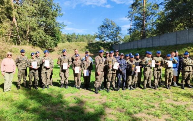 Uczestnicy zawodów strzeleckich. Część trzyma dyplomy.