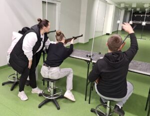 Strzelnica- uczennica i uczeń strzelający oraz instruktor