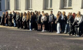 apel_odzyskanie_niepodleglosci20 Grupa młodzieży i nauczycieli na dziedzińcu szkoły.