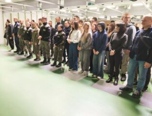 zawody_strzeleckie01 Młodzież oraz opiekunowie wewnątrz sali. Część młodzieży w umundurowaniu.