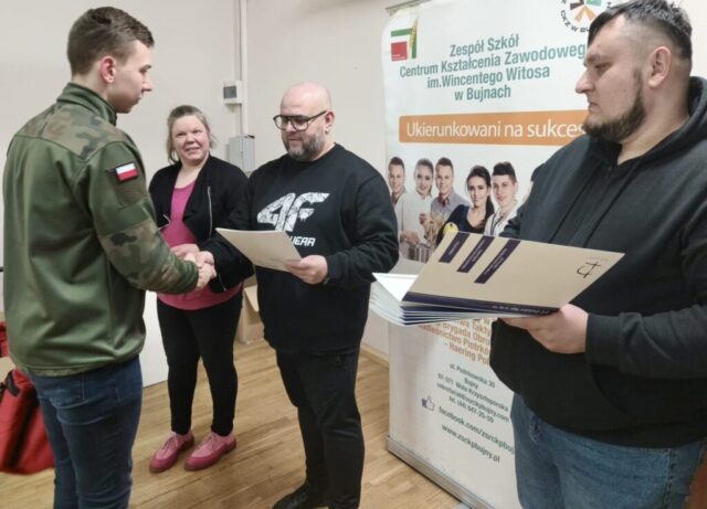Uczestnik kursu odbiera z rąk organizatorów dyplom. W tle baner reklamowy ZS CKZ im. Wincentego Witosa w Bujnach.
