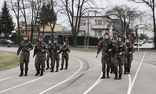 Kadeci klasy OPW w umundurowaniu podczas przemarszu, prezentują broń.