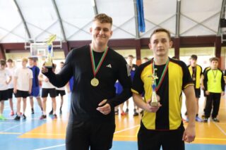 pilka_nozna_halowa11 Dwóch zawodników prezentuje trofea i medale zdobyte w rozgrywkach.