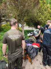 oboz_zloty_potok11 Porządkowanie sprzętu po zajęciach — uczestnicy sortują odzież i wyposażenie na ławkach w terenie leśnym.