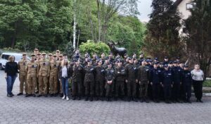 szkolenie_zloty_potok Zdjęcie grupowe uczestników szkolenia — duża grupa osób w różnych mundurach wraz z opiekunami stoi na placu.