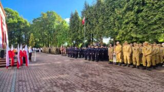 Rozpoczecie_roku_szkolnego1 Uczestnicy w różnych mundurach stoją w szyku na placu podczas oficjalnej uroczystości.