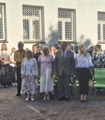 Rozpoczecie_roku_szkolnego2 Grupa osób stoi w rzędach przed budynkiem podczas szkolnego wydarzenia.