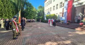 rozpoczecie_roku_szkolnego Uczestnicy oraz poczet Sztandarowy stoją w formacji przed budynkiem podczas uroczystości rozpoczęcia roku szkolnego.