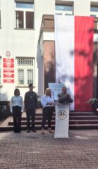 Rozpoczecie_roku_szkolnego7 Kilka osób stoi przy podium przed budynkiem podczas rozpoczęcia roku szkolnego.