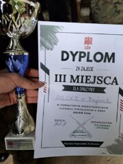 turniej_kbks2 Osoba prezentuje puchar oraz dyplom za trzecie miejsce w zawodach strzeleckich.