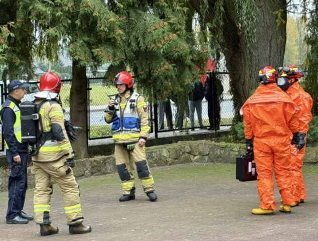 Funkcjonariusze służb mundurowych uczestniczący w ćwiczeniach na terenie szkoły.