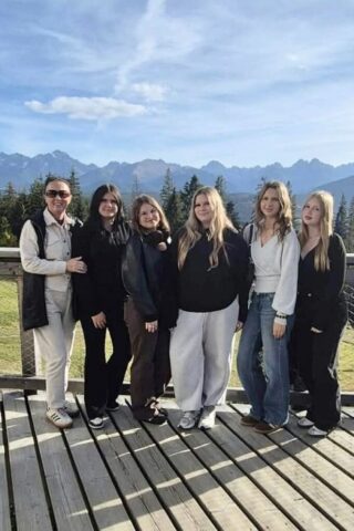 wycieczka_zakopane02 Uczennice i opiekun na platformie widokowej z panoramą gór.